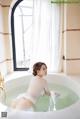 A woman sitting in a bathtub in a bathroom.