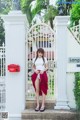 A woman standing in front of a white gate.