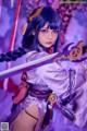 A woman in a purple outfit holding a sword.