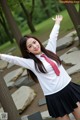 A woman in a school uniform posing for a picture.