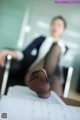 A woman in black stockings sitting at a desk with her feet up.