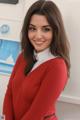 A woman in a red sweater posing for a picture.