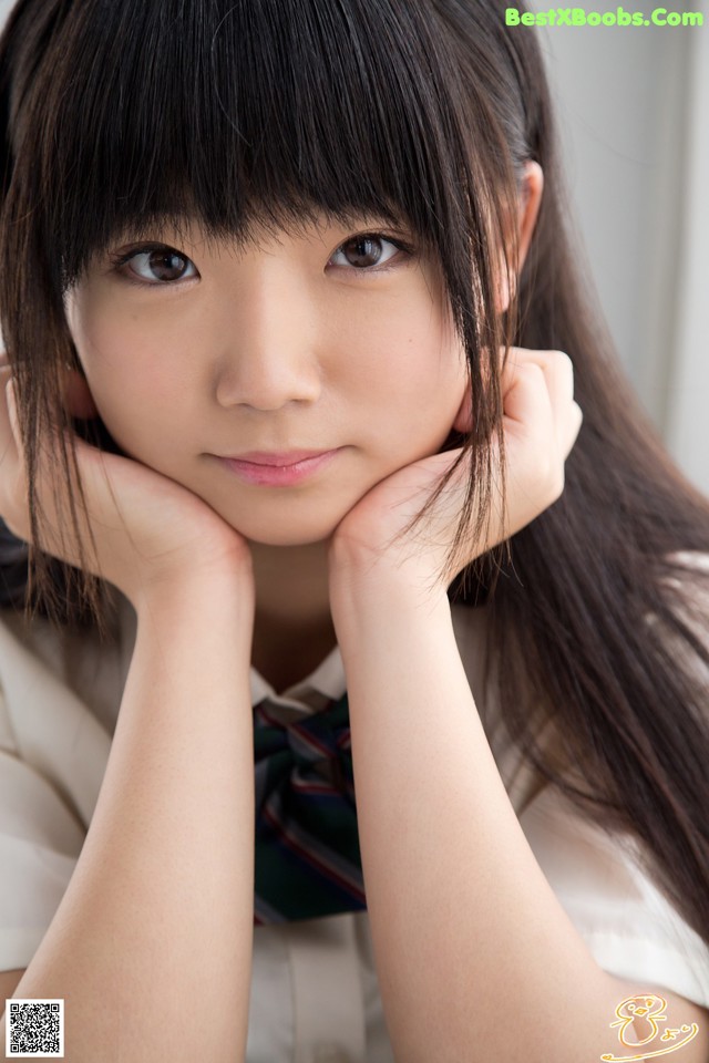 A young woman in a school uniform posing for a picture.
